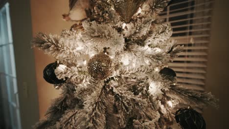 Adornos-Dorados-Y-Verdes-En-Un-árbol-De-Navidad-Cubierto-De-Nieve