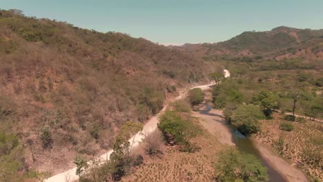 aerial tilt reveal shot of empty rural road in costa rican wilderness