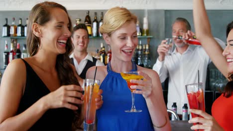 Portrait-of-happy-friends-are-holding-cocktail-and-clinking-glasses