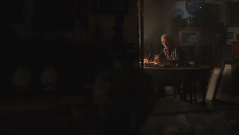 old passionate man read a book in his office at night