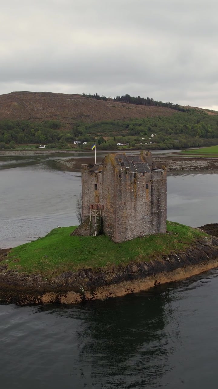 Pittoresco Castello Stalker medievale che si erge su un isolotto tidale nel Loch Laich, Scozia. Splendida vista aerea del monumento storico.