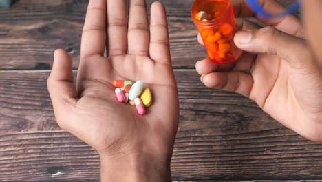 person pouring pills from a container onto their hand