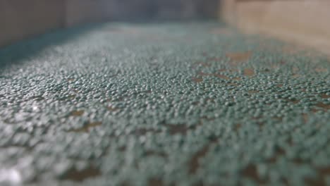 close-up shot of water conduit moving recycled plastic at a waste management facility