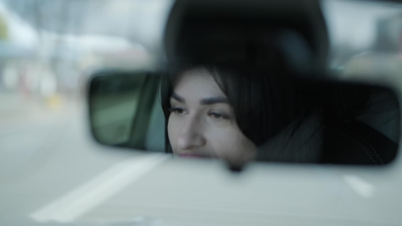 고급스러운 비즈니스 의상을 입고 현대적인 차량 인테리어에서 독립성과 전문성을 보여주는 자신감 넘치는 사업가 여성이 차를 운전하고 있습니다.