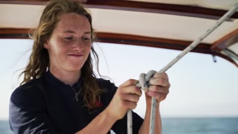 sailing enthusiast mastering knots on a boat amidst the ocean's breeze: capturing the art of knot tying with focus and precision in choppy waters