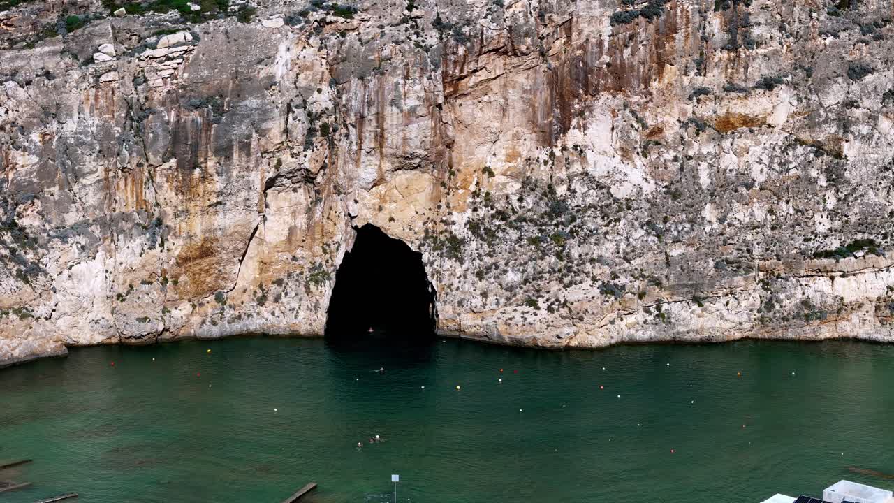 Majestic Limestone Sea Cave at Inland Sea Gozo Malta During a Bright Summer Day Featuring Deep Turquoise Waters and Rugged High Cliffs Captured from a High Angle Viewpoint to Reveal Natural Beauty