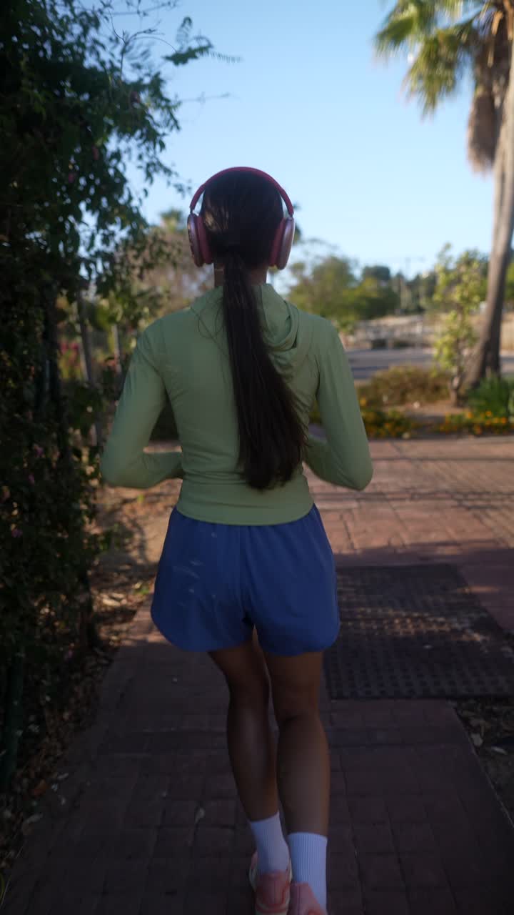 mujer corriendo al aire libre con auriculares