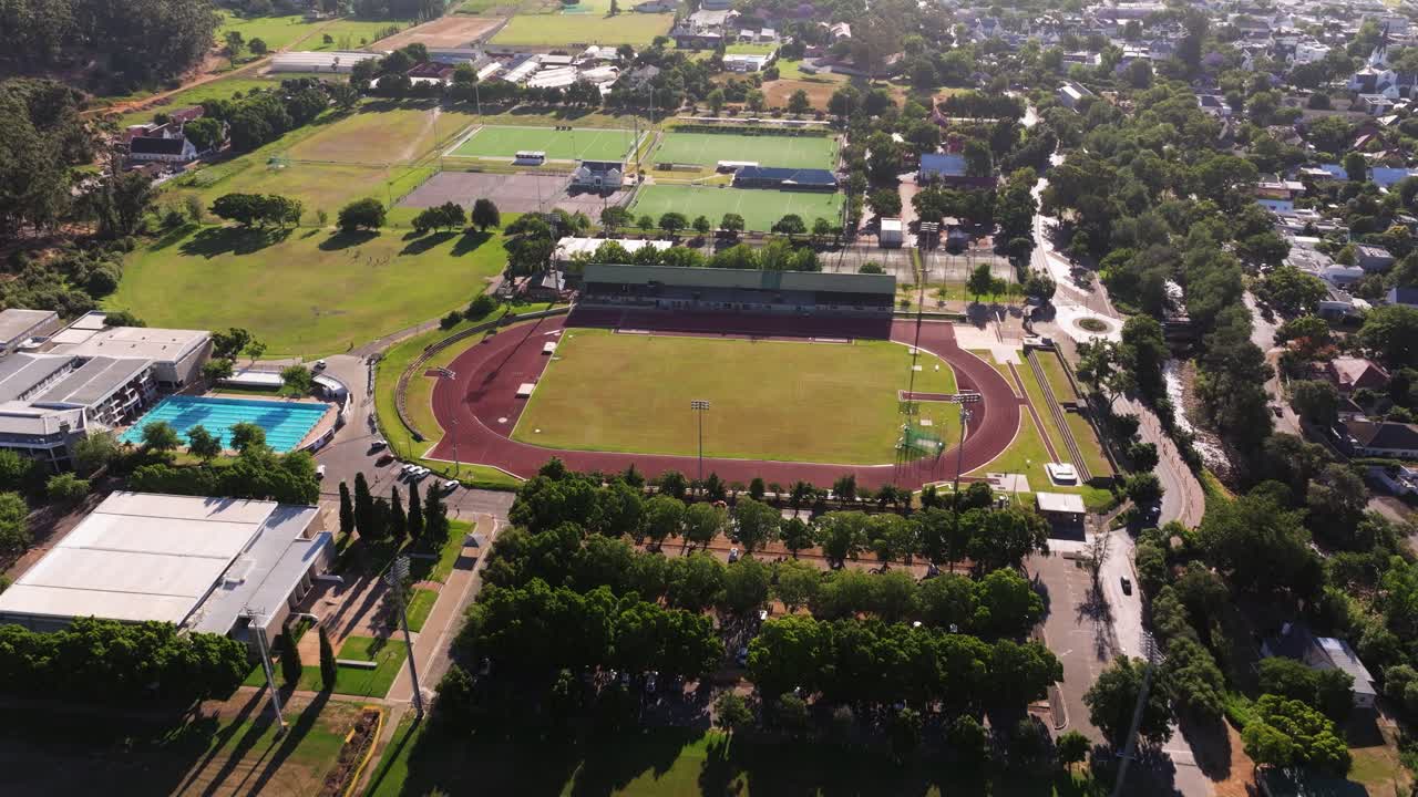 drone aéreo disparado por encima del complejo deportivo con pista, hockey de campo, canchas de netball