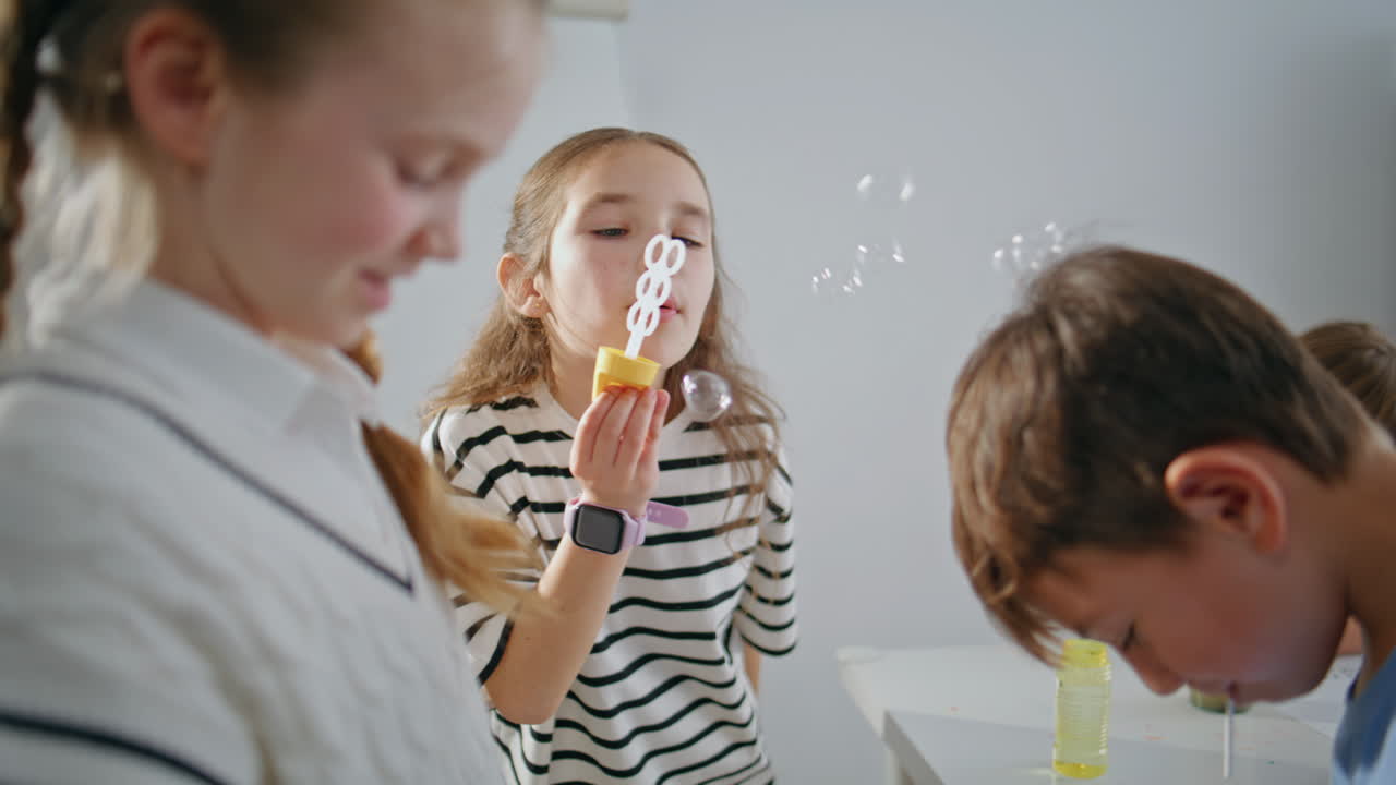 Carefree schoolgirl blowing soap bubbles school break closeup. Children resting