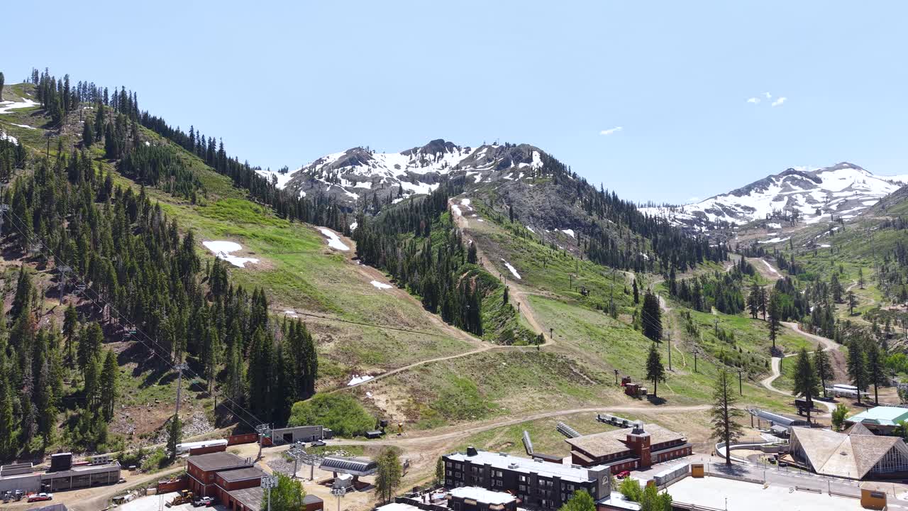 Palisades Tahoe Ski Resort in Summer Season, Drone Shot of Ski Tracks, Snow Capped Peaks and Buildings, Olympic Valley California USA