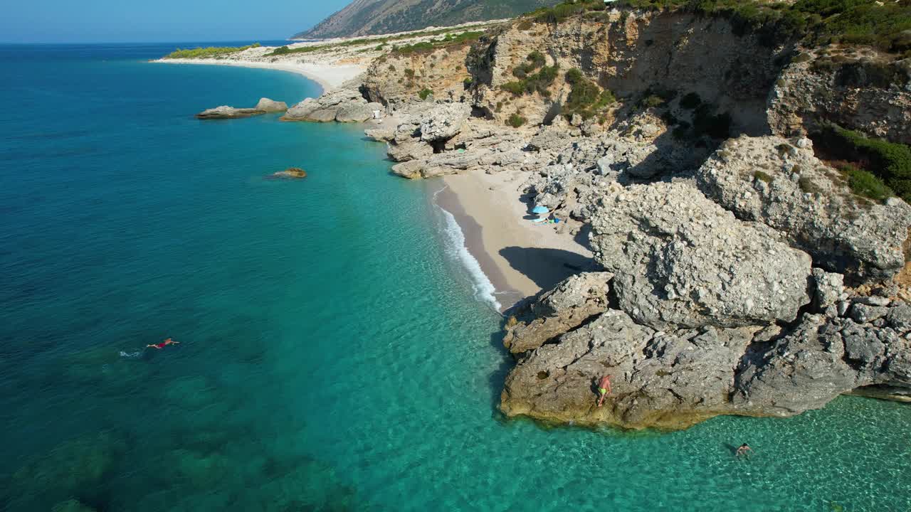 Remote pristine beach on the rocky shore of the Mediterranean, with white sand and crystal blue sea