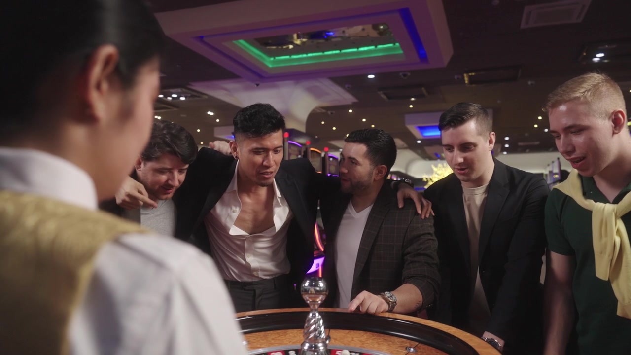 Filmato reale di giocatori di casinò che giocano alla roulette rossa e nera mentre bevono e si divertono, ideale per uno spot pubblicitario