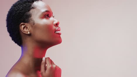 African-american-woman-with-short-dark-hair-in-blue-and-pink-light-with-copy-space,-slow-motion