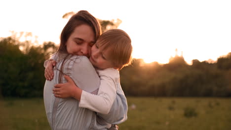 loving mother and son hugging outdoors sunset. loving mother and son hugging outdoors on sunset during their summer vacation