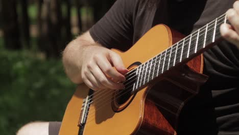 guitarra de cerca hombre tocando guitarra clásica acústica con los dedos