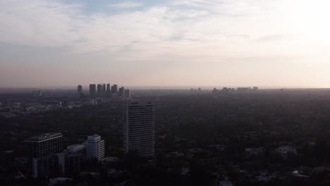 Toma-Aérea-Amplia-De-La-Ciudad-Del-Siglo-Y-Las-Colinas-De-Beverly-Con-Poca-Luz-De-La-Tarde