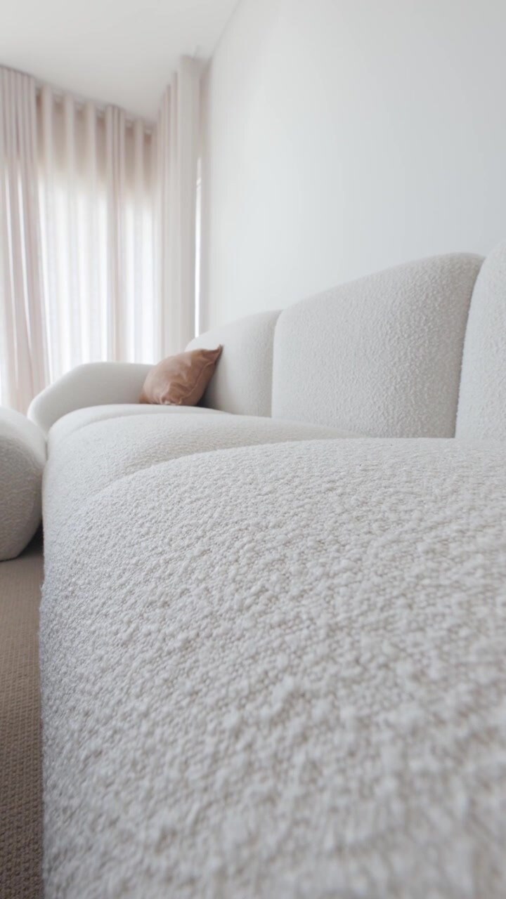 Sofá de bouclé blanco en el interior de una sala de estar minimalista y moderna