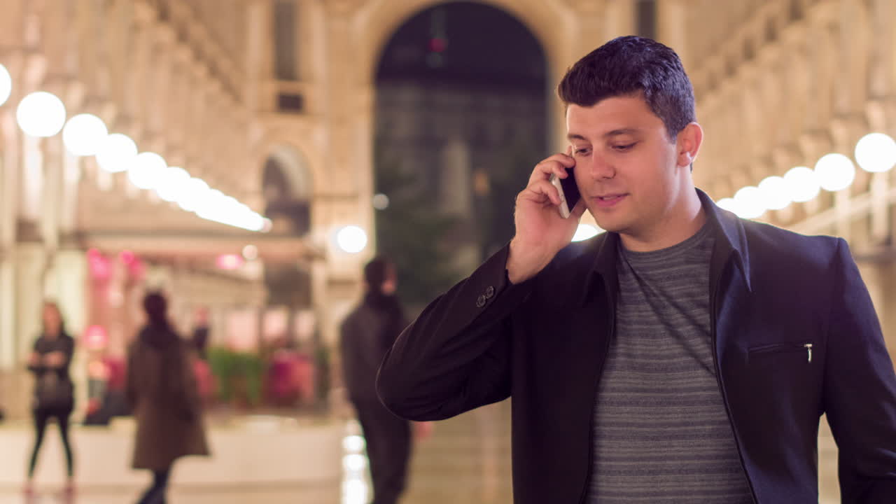 밤에 도시에서 전화로 이야기하는 남자