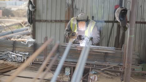trabajador de la construcción que soldaba barras de refuerzo metálicas para el vertido de estructuras monolíticas