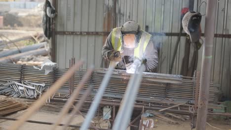 construction worker welding metal rebar for the pouring of monolithic structure