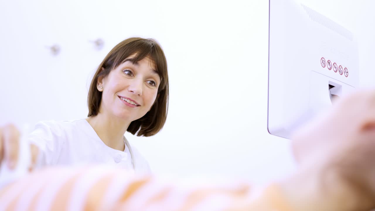 Friendly female doctor smile during a ultrasound to pregnant woman