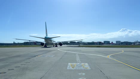 airplane moving on runway under clear blue sky