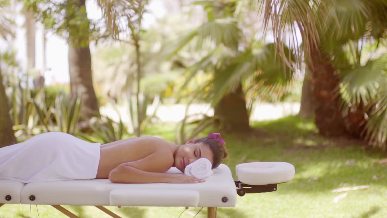 mujer joven en un spa al aire libre en un complejo tropical