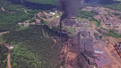 aerial view of dark toxic smoke rising up from stack of mine plant in dominican republic - sad environmental pollution of earth