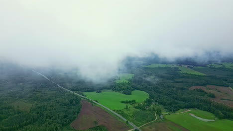 Aerial-View-Through-the-Thick-Clouds-Over-Countryside-Landscape-of-Latvia