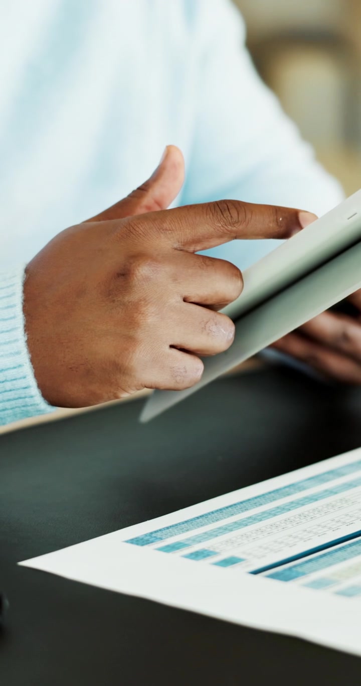 Person Using Tablet While Reviewing Financial Documents