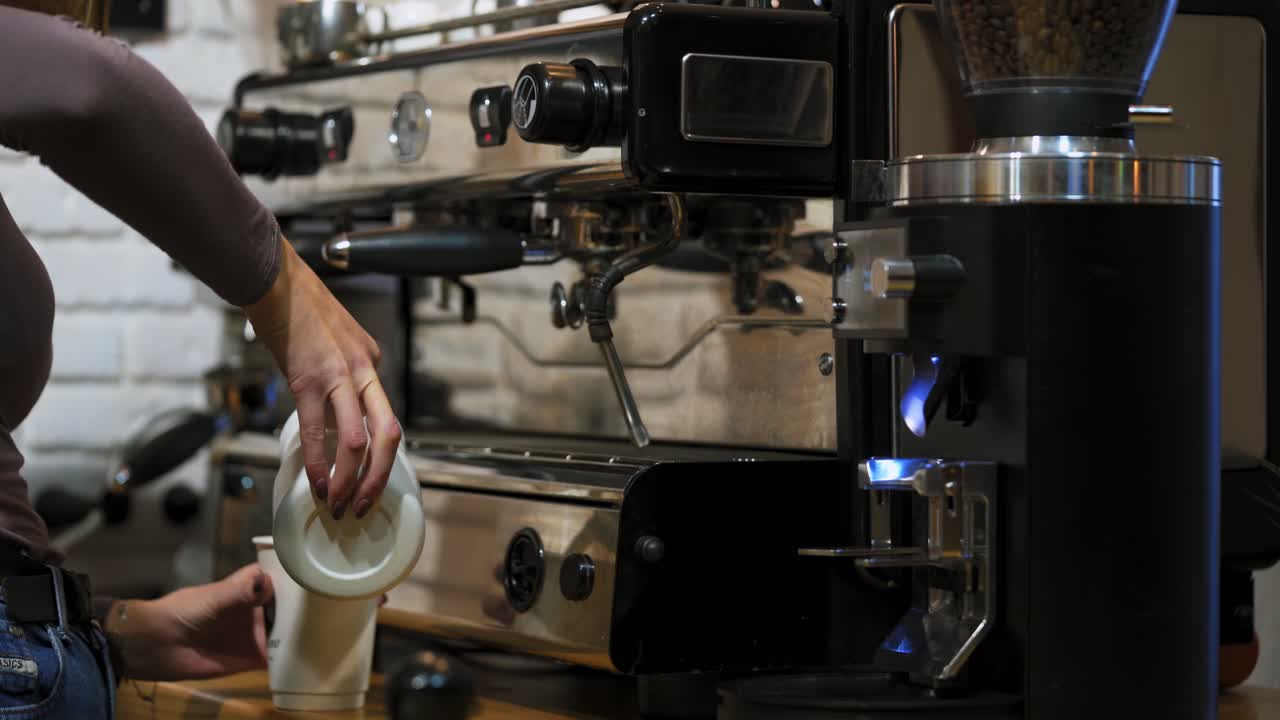 Coffee latte art in coffee shop. Professional barista pouring milk and preparing fresh coffee