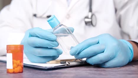médico con desinfectante para manos y pastillas