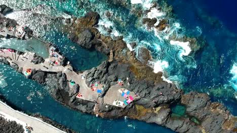 aerial drone footage of the natural pools of garachico caletón. blue ocean and the natural pools functioning as playas at tenerife. nice waves hit the rocks in the water.