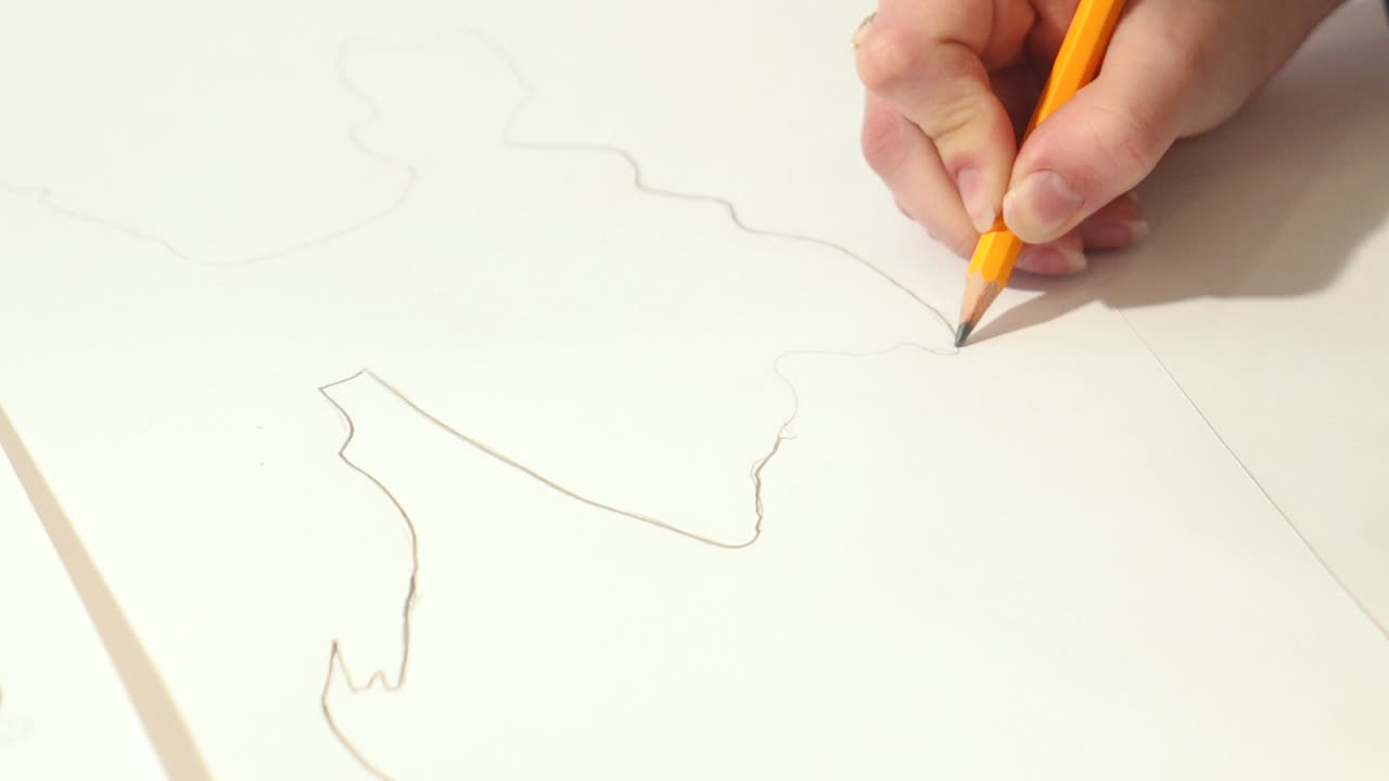 Female hands with a graphite pencil. Young woman learns to draw.
