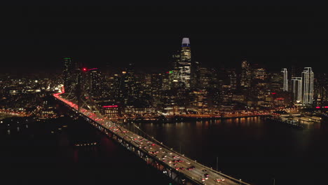 stationary aerial shot of downtown san francisco from the bay bridge at night