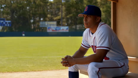 baseball player sitting in dugout