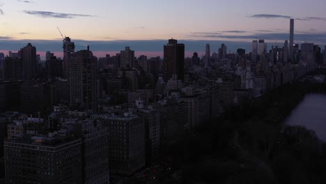 épico-Sobrevuelo-De-Drones-Del-Embalse-Onassis-Del-Parque-Central-De-La-Ciudad-De-Nueva-York-Con-Una-Gran-Vista-De-La-5ta-Avenida-Y-El-Lado-Este-Superior-Al-Amanecer-Amanecer-Hora-Azul