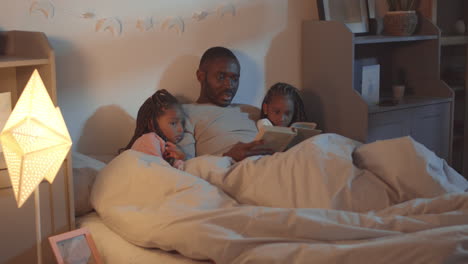 reading book to kids in bed