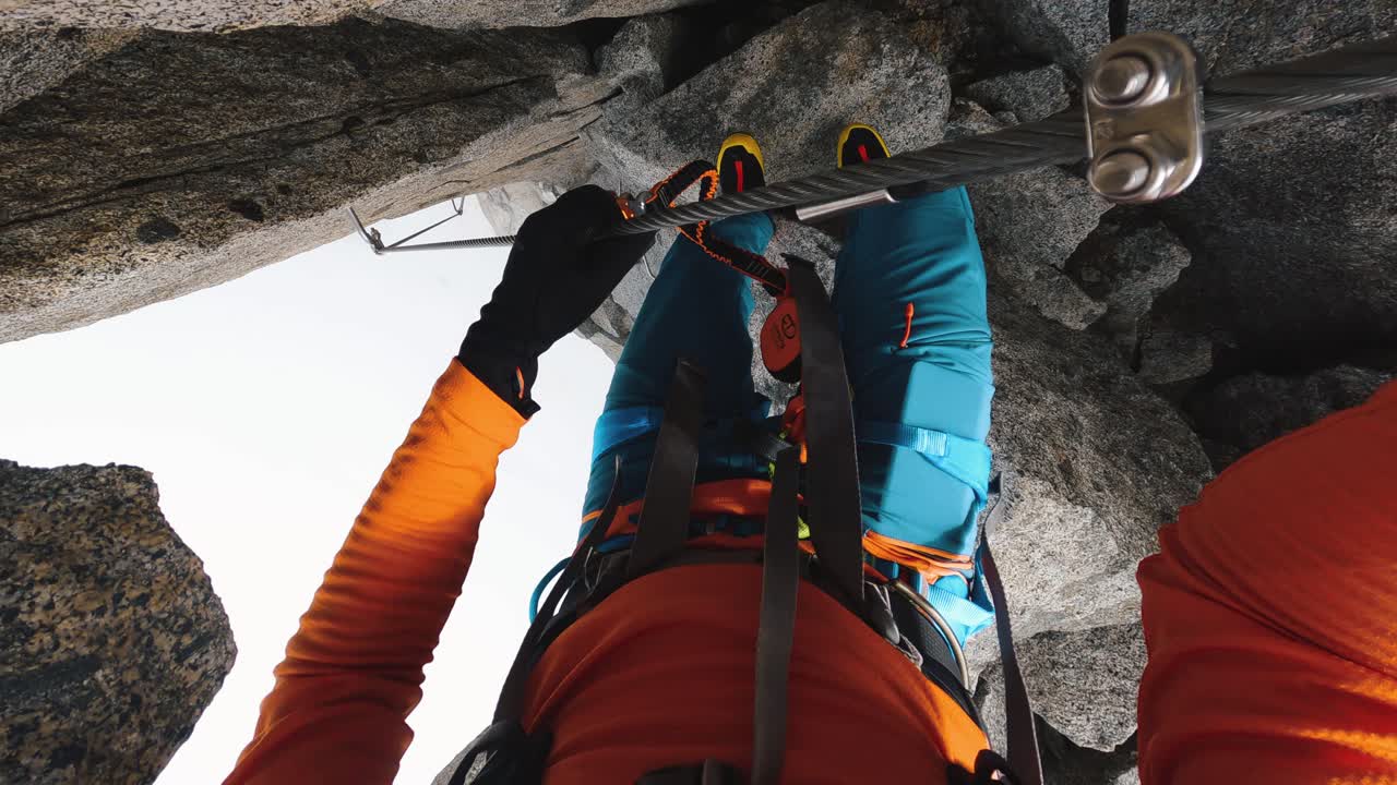un montañero baja atado a un cable de acero