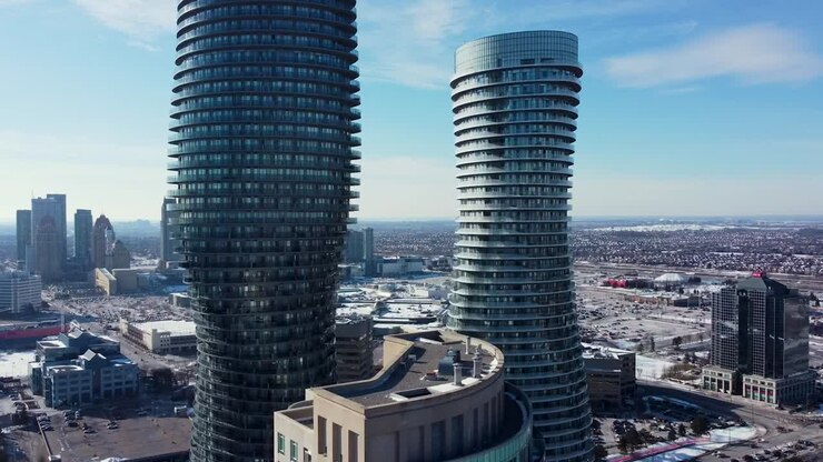 Close-up aerial shot flying towards tall spiral Mississauga apartment buildings