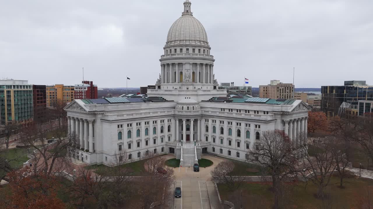 Vista aérea de Madison, Wisconsin, destacando o edifício do Capitólio Estadual e a densa paisagem urbana ao redor.