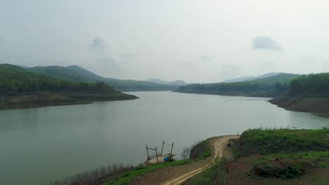 vista aérea de 4k de un río tranquilo rodeado de montañas y cielo despejado en tailandia