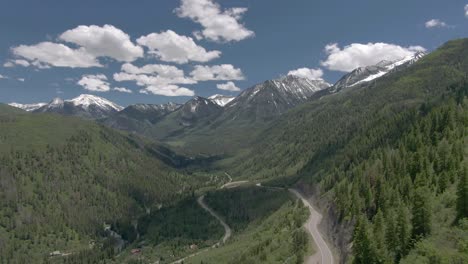 la vista aérea se mueve hacia abajo para mostrar una vista de la hermosa y sinuosa carretera de colorado