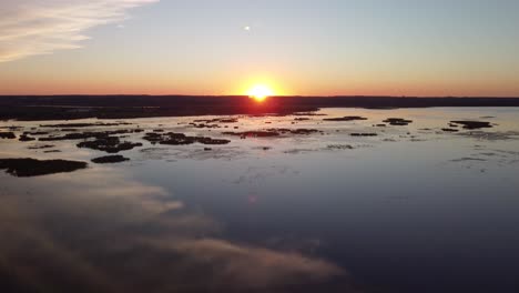 vista de drones de grúa al atardecer sobre un lago, humedales con un río en el fondo