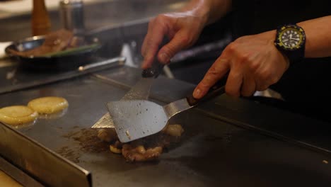 chef skillfully prepares food on teppan grill