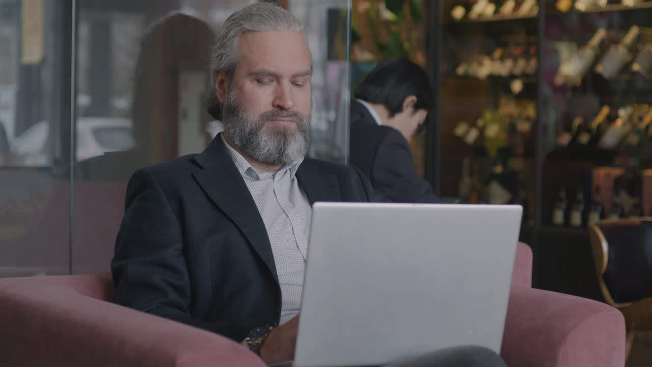 Man Working on Laptop in a Cafe