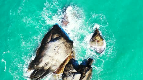 Peaceful-scene-with-turquoise-lagoon-water-splashing-and-foaming-on-limestone-cliffs-on-a-sunny-day-in-Myanmar