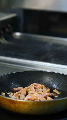 cocinando tocino en una sartén