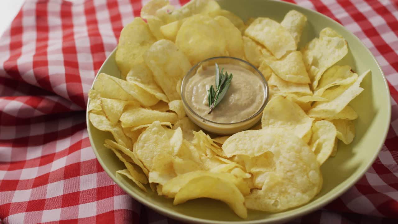 Video of crisps and cheese dip on a wooden surface