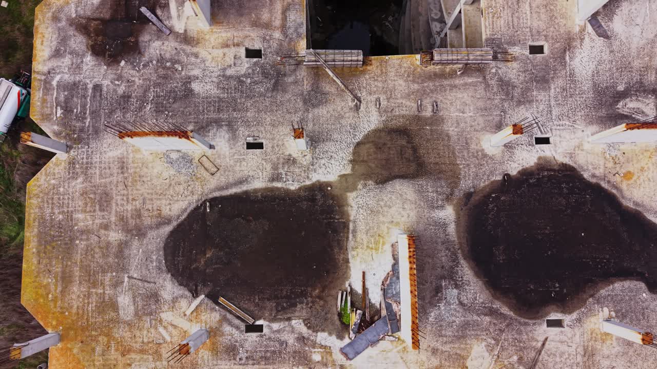 Aerial view of an abandoned rooftop with debris and greenery